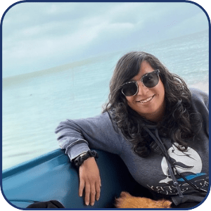 Smiling person with sunglasses on a boat by the sea on a sunny day.